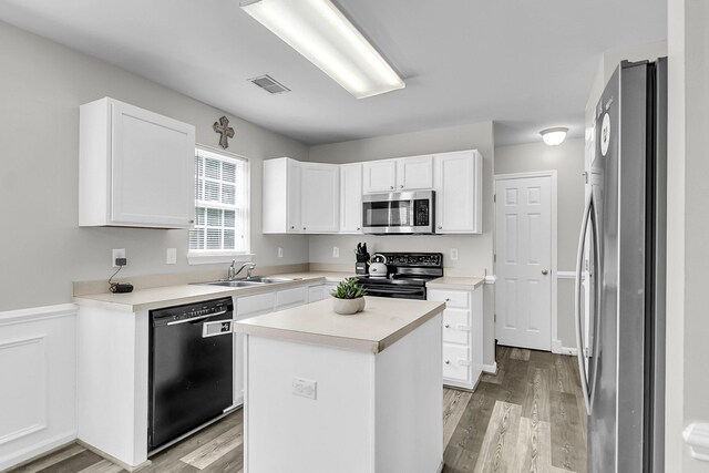 125 Towering Pine Dr, Ladson, SC 29456 - kitchen featuring black appliances, light wood-style floors, white cabinets, a sink, and a kitchen island