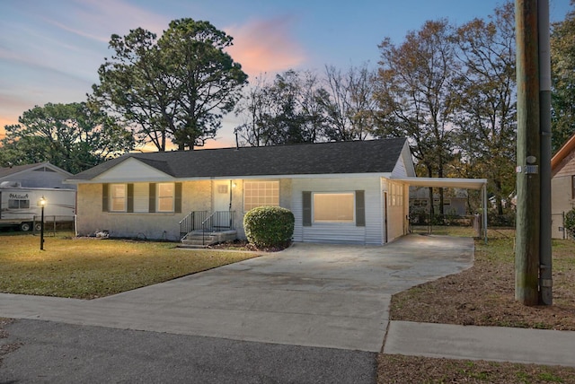 view of front of house featuring a carport and a yard