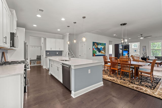 kitchen featuring tasteful backsplash, dark wood-style floors, stainless steel appliances, light countertops, and a sink