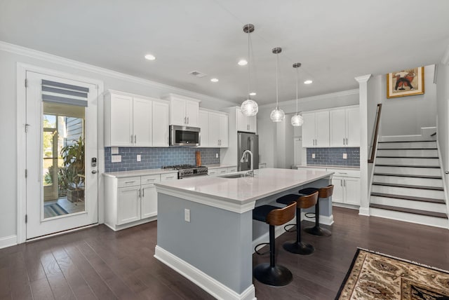 kitchen with high end appliances, white cabinetry, dark wood finished floors, and ornamental molding