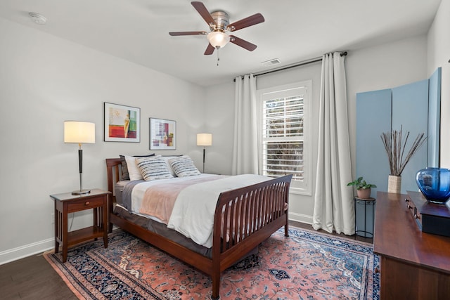 bedroom featuring ceiling fan, wood finished floors, visible vents, and baseboards