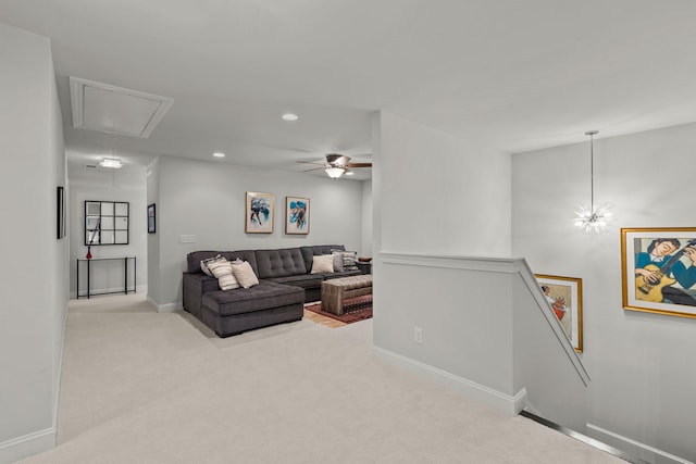 carpeted living room with attic access, baseboards, and recessed lighting