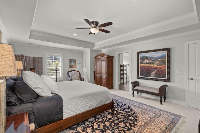 carpeted bedroom featuring crown molding, a tray ceiling, a ceiling fan, and baseboards