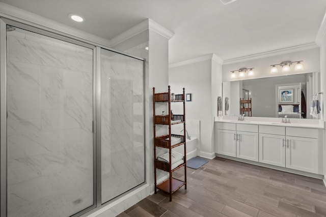 full bath with a marble finish shower, double vanity, ornamental molding, wood finished floors, and baseboards