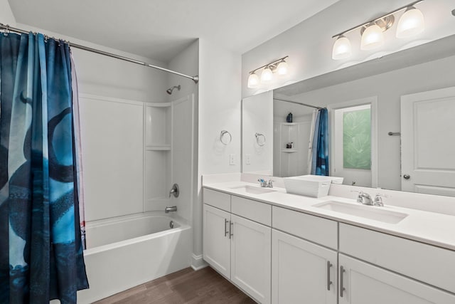 bathroom featuring double vanity, wood finished floors, shower / bath combo, and a sink