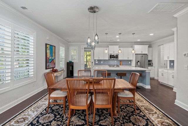 dining room featuring dark wood-style floors, baseboards, visible vents, and crown molding