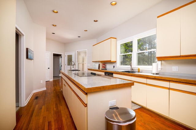 kitchen featuring dark wood-style flooring, a sink, black electric cooktop, and recessed lighting