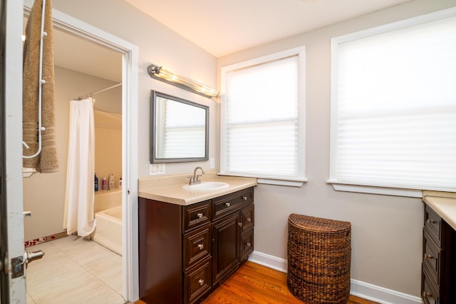 full bath featuring shower / bathtub combination with curtain, vanity, and baseboards