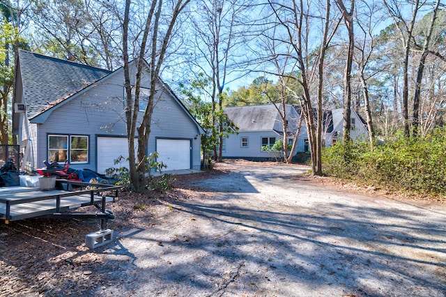 view of home's exterior featuring a garage, driveway, and roof with shingles