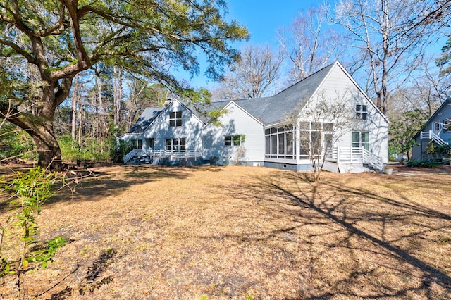 rear view of house featuring a shingled roof, crawl space, and a sunroom