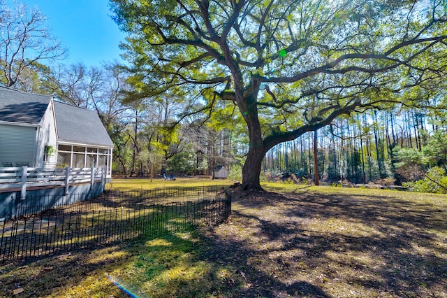 view of yard featuring fence and a sunroom