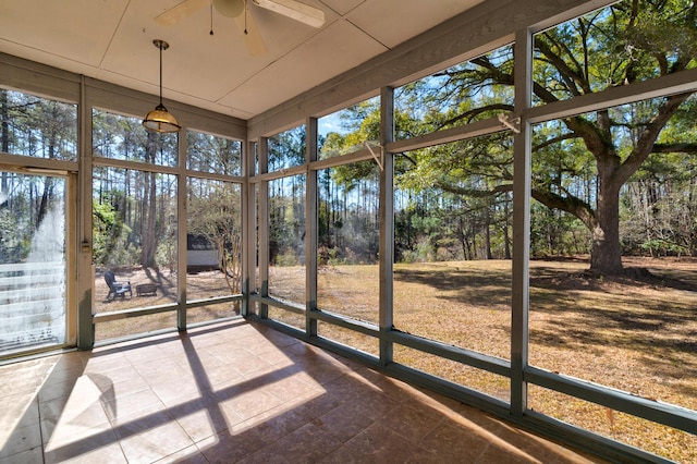 unfurnished sunroom featuring a ceiling fan and a healthy amount of sunlight