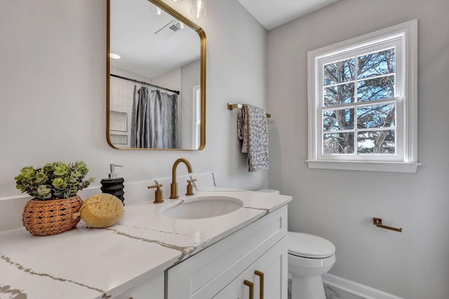 bathroom with vanity, toilet, and curtained shower