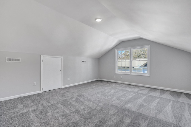 bonus room featuring vaulted ceiling and carpet