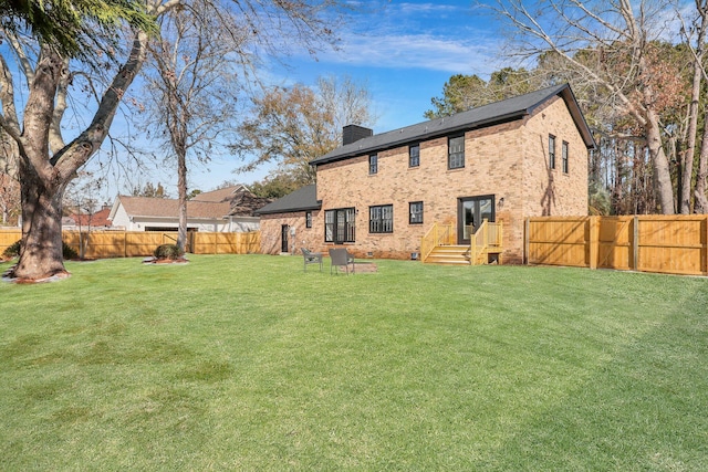 rear view of property featuring a yard