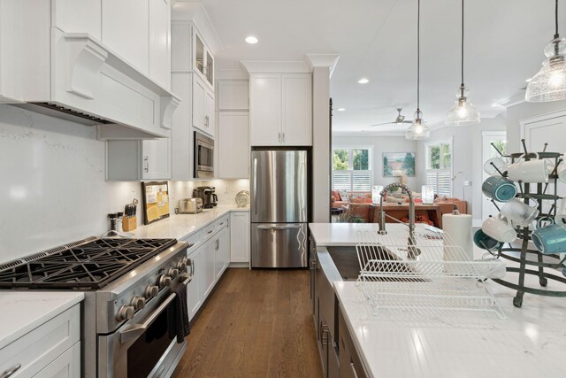 kitchen featuring dark hardwood / wood-style floors, decorative light fixtures, stainless steel appliances, light stone counters, and white cabinets