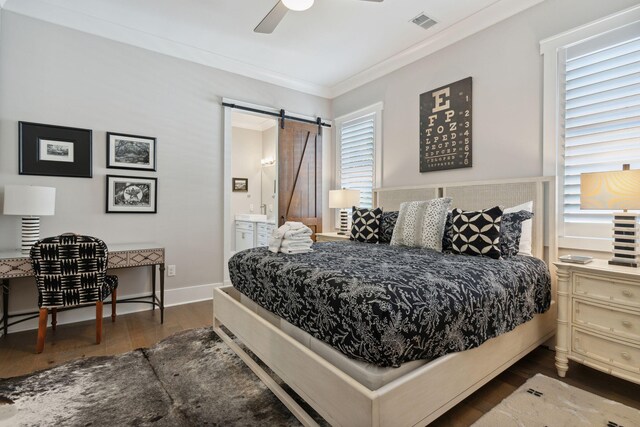 bedroom with dark hardwood / wood-style floors, ensuite bathroom, a barn door, ceiling fan, and multiple windows