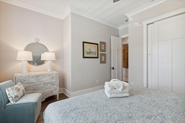 bedroom with crown molding, dark wood-type flooring, and a closet