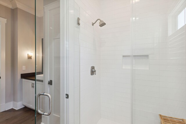 bathroom featuring vanity, wood-type flooring, and walk in shower