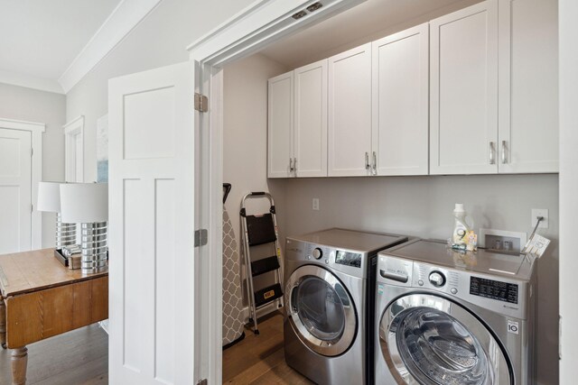 washroom with crown molding, cabinets, washer and clothes dryer, and dark wood-type flooring