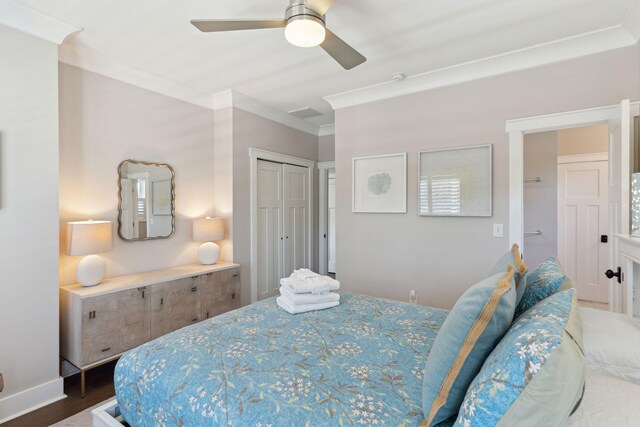 bedroom with hardwood / wood-style floors, ceiling fan, a closet, and crown molding