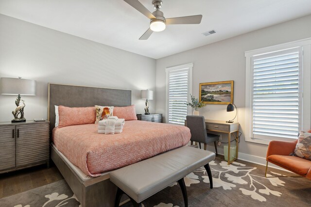 bedroom with multiple windows, dark wood-type flooring, and ceiling fan