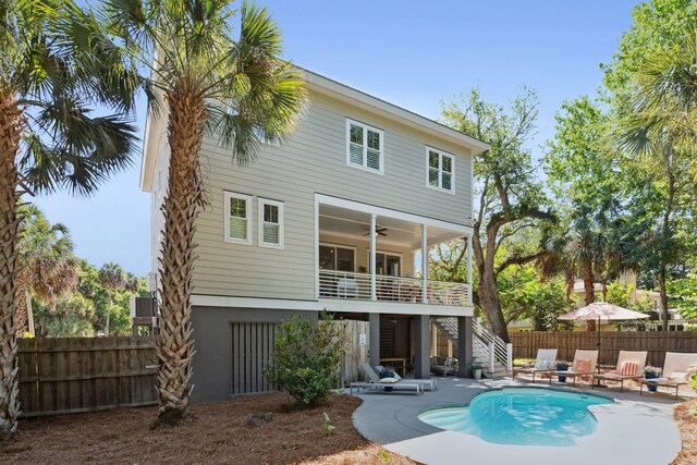 back of house with a fenced in pool, a patio area, ceiling fan, and a balcony