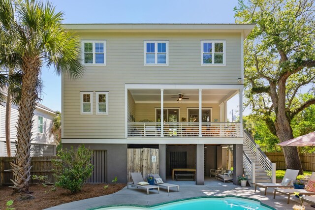 back of property with a fenced in pool, ceiling fan, a patio area, and an outdoor living space