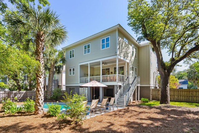 rear view of property with ceiling fan and a patio area