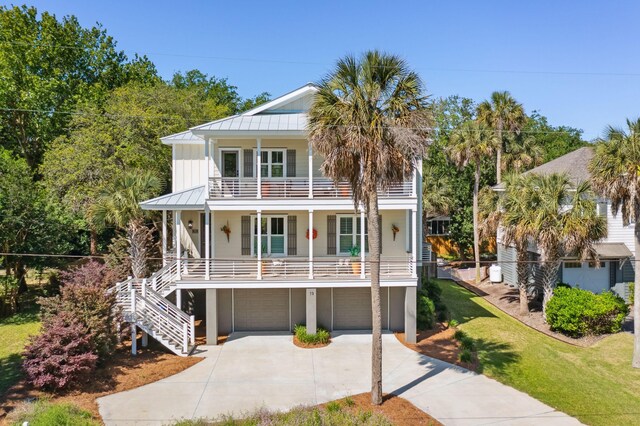 view of front of property featuring a balcony, a garage, a front yard, and a porch