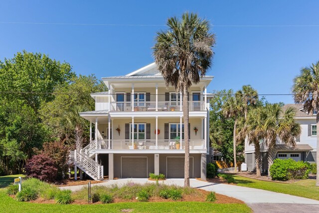 raised beach house with a balcony, a garage, and a porch