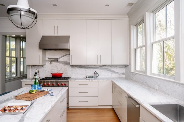 222 Haddrell St, Mount Pleasant, SC 29464 - kitchen with under cabinet range hood, white cabinetry, light stone counters, and tasteful backsplash