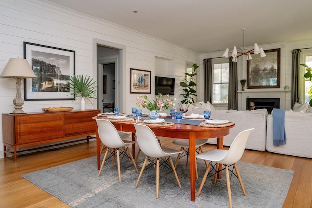 222 Haddrell St, Mount Pleasant, SC 29464 - dining room with ornamental molding, a chandelier, wood finished floors, a fireplace, and wood walls