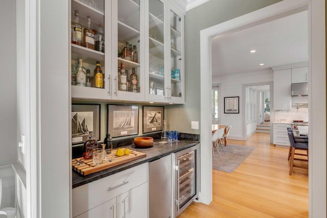 222 Haddrell St, Mount Pleasant, SC 29464 - indoor bar with wine cooler, ornamental molding, light wood-style flooring, under cabinet range hood, and tasteful backsplash