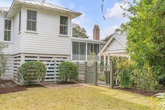 222 Haddrell St, Mount Pleasant, SC 29464 - rear view of property featuring a sunroom, a standing seam roof, metal roof, a chimney, and a gate