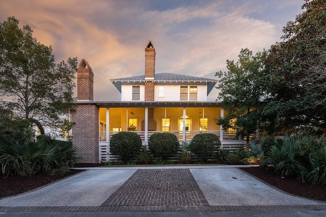 222 Haddrell St, Mount Pleasant, SC 29464 - view of front of house featuring a chimney, a porch, a standing seam roof, and metal roof