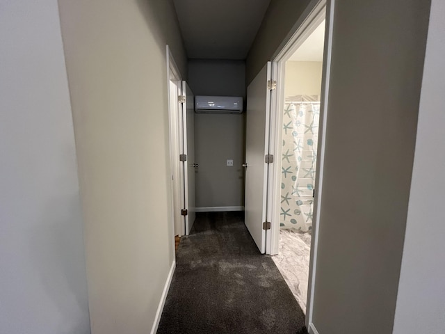 hallway featuring dark colored carpet and a wall mounted AC