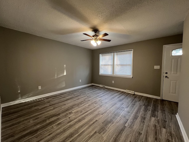 spare room with ceiling fan, dark wood-type flooring, and a textured ceiling