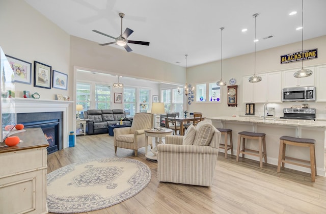 5078 Song Sparrow Way, Summerville, SC 29483 - living area with a high ceiling, light wood-style floors, a ceiling fan, a glass covered fireplace, and recessed lighting