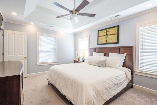 bedroom featuring visible vents, baseboards, ornamental molding, light carpet, and a tray ceiling