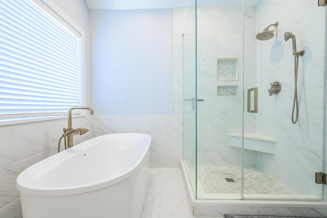 bathroom with a healthy amount of sunlight, a stall shower, and a soaking tub