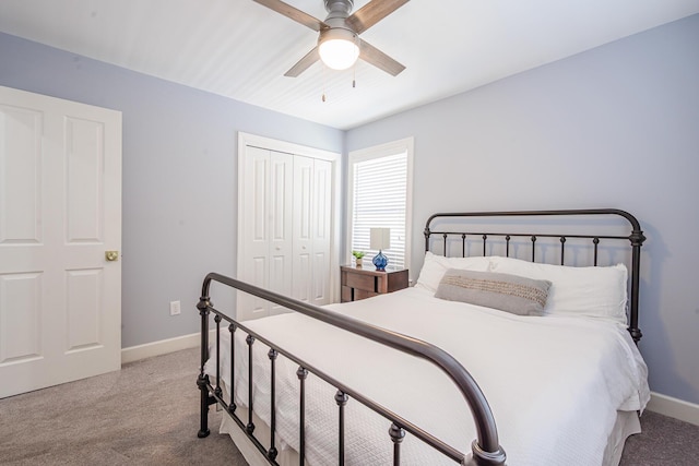 carpeted bedroom featuring a closet, baseboards, and a ceiling fan