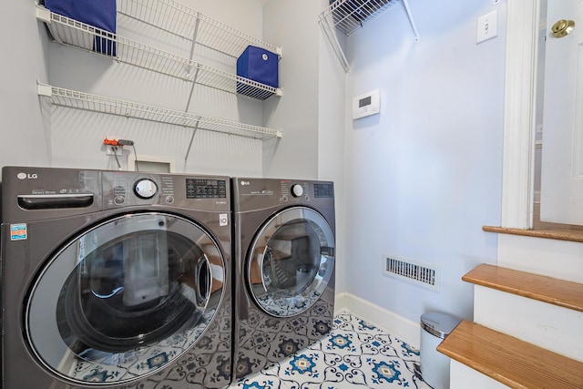 laundry room with baseboards, visible vents, washing machine and dryer, and laundry area