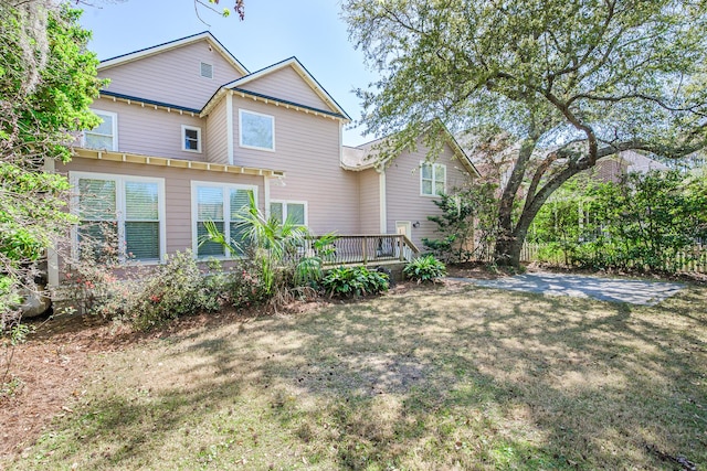back of property with a lawn and a deck