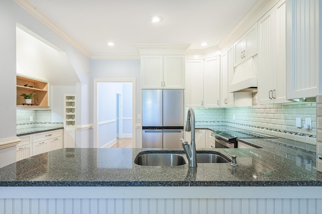 kitchen featuring range with electric stovetop, dark stone countertops, under cabinet range hood, and a sink