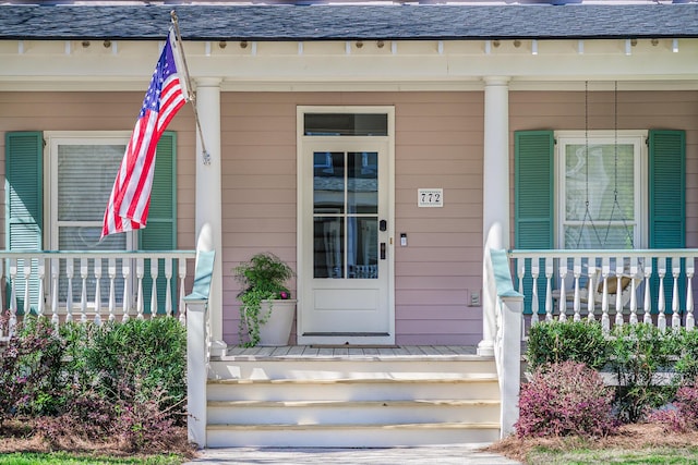 view of exterior entry featuring covered porch