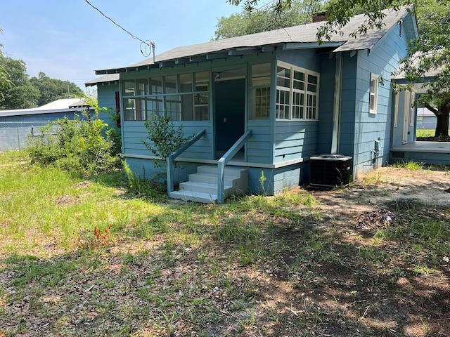 view of front of home with a sunroom and cooling unit