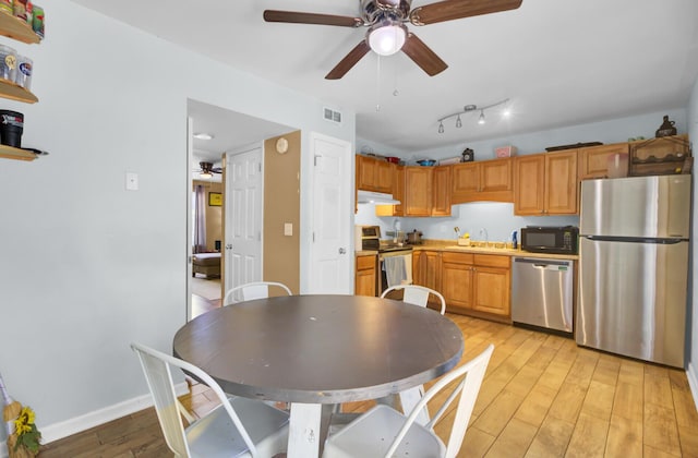 4662 Nibbs Ln, North Charleston, SC 29418 - kitchen featuring stainless steel appliances, under cabinet range hood, a ceiling fan, light wood-type flooring, and a sink