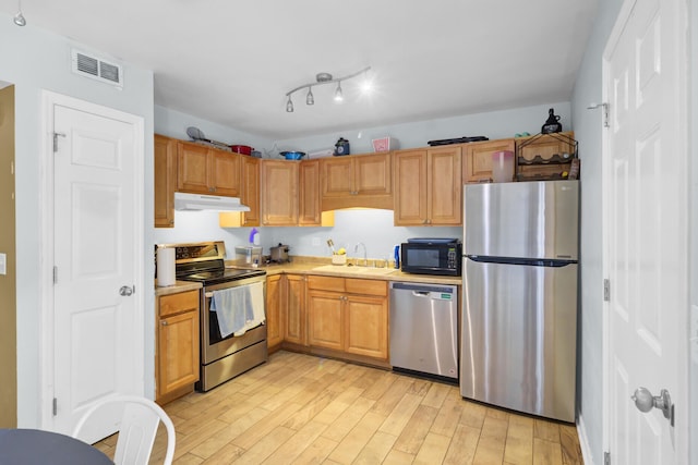 4662 Nibbs Ln, North Charleston, SC 29418 - kitchen with appliances with stainless steel finishes, under cabinet range hood, a sink, light wood-style flooring, and light countertops