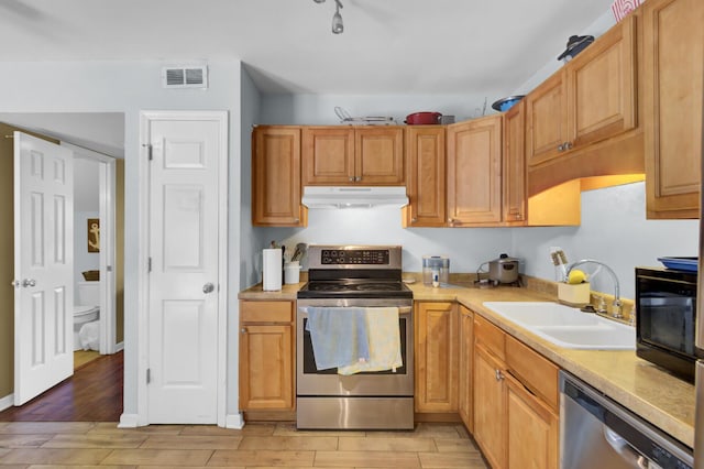 4662 Nibbs Ln, North Charleston, SC 29418 - kitchen with appliances with stainless steel finishes, under cabinet range hood, a sink, light wood-type flooring, and light countertops
